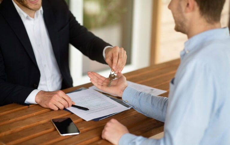 An agent handing over keys to a home