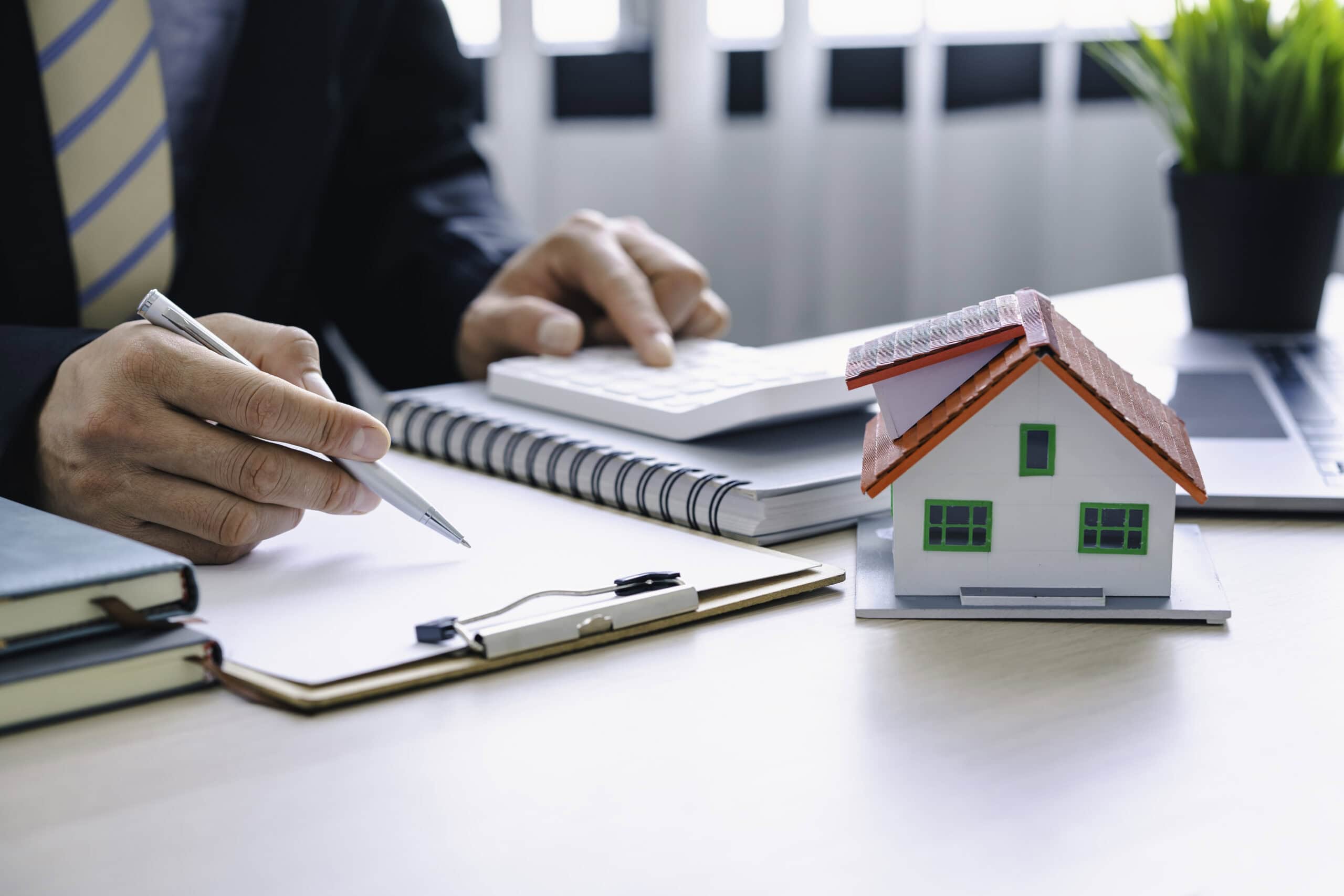 A real estate agent with a model of a home